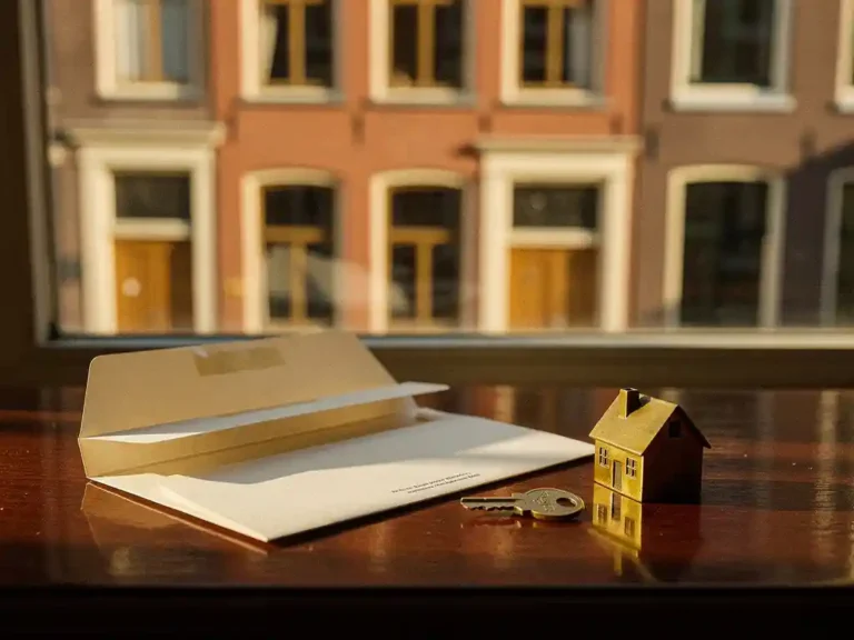 Klassieke Nederlandse rijtjeswoning weerspiegeld in houten tafel naast belastingdocument en messing huissleutel, warm middaglicht.